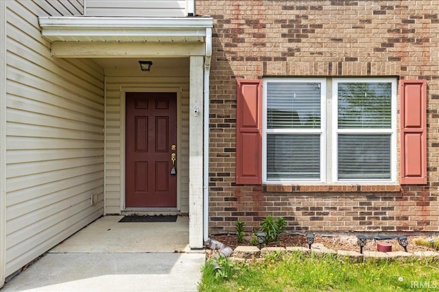 doorway to property with brick siding