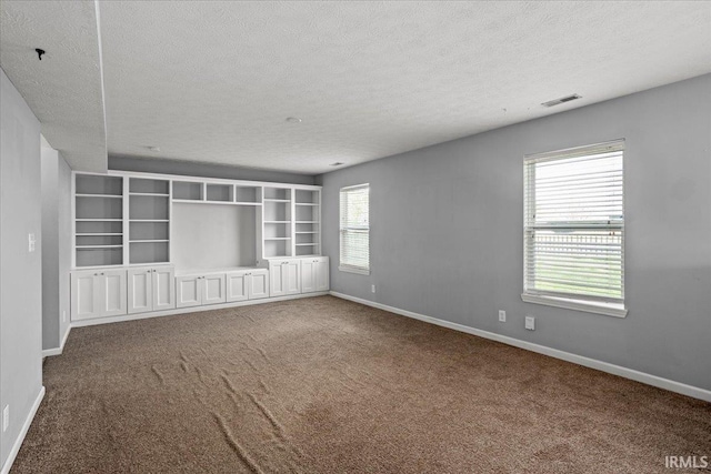 carpeted empty room featuring baseboards and a textured ceiling