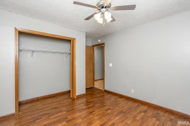 unfurnished bedroom with a closet, wood finished floors, baseboards, ceiling fan, and a textured ceiling