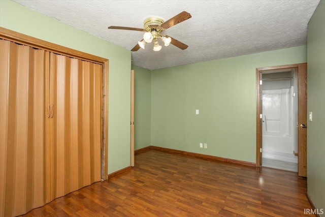 unfurnished bedroom featuring a ceiling fan, a textured ceiling, wood finished floors, baseboards, and a closet
