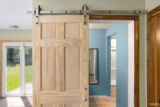 interior details featuring baseboards, visible vents, and a barn door