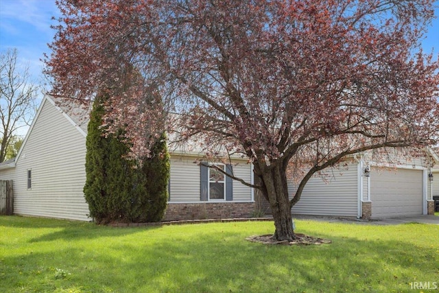 view of property exterior featuring an attached garage, a lawn, and driveway