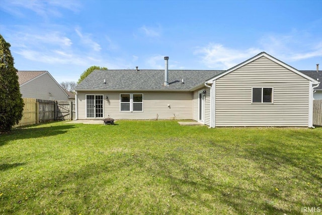 rear view of property with a fenced backyard and a yard