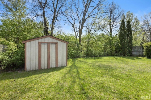 view of yard featuring fence, an outbuilding, and a storage shed