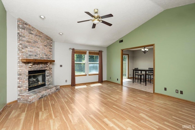 unfurnished living room with a brick fireplace, wood finished floors, baseboards, high vaulted ceiling, and ceiling fan with notable chandelier