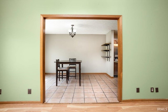 dining room featuring an inviting chandelier, light tile patterned floors, and baseboards