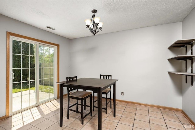 dining space with light tile patterned floors, baseboards, visible vents, and a notable chandelier