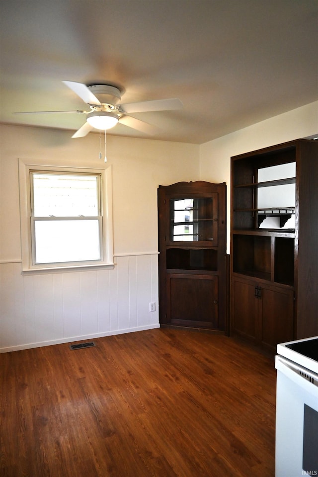 interior space featuring dark wood-style flooring, ceiling fan, visible vents, and plenty of natural light