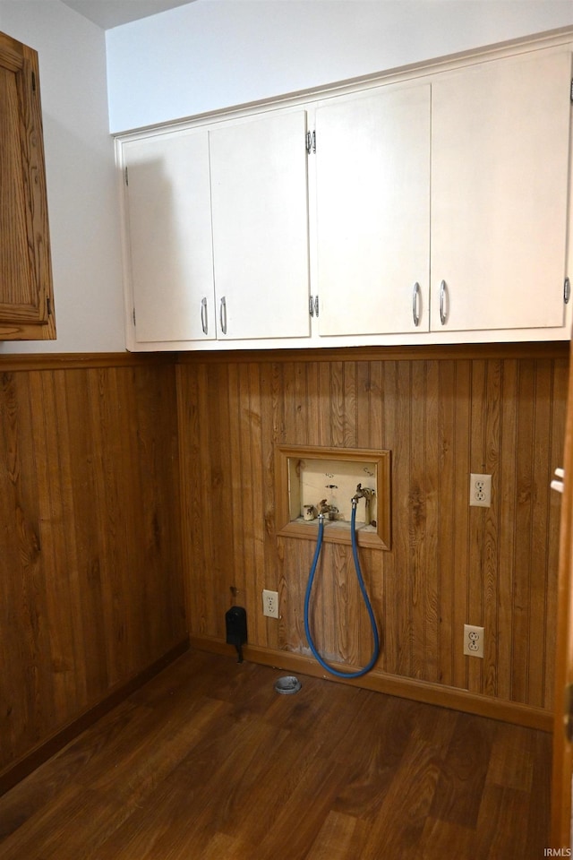 laundry room featuring washer hookup, wainscoting, wood walls, cabinet space, and wood finished floors