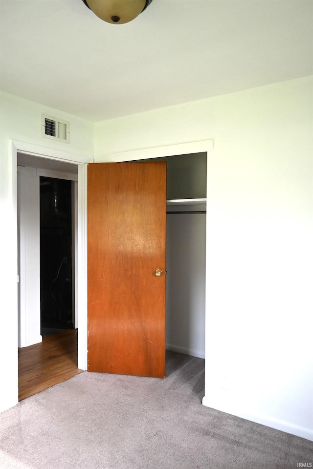 unfurnished bedroom featuring carpet, a closet, and visible vents