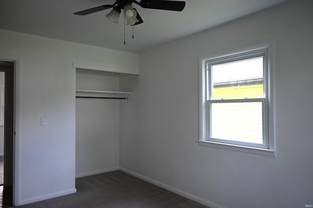 unfurnished bedroom with baseboards, ceiling fan, carpet, and a closet