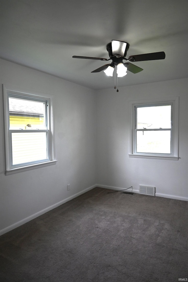 empty room with visible vents, a ceiling fan, plenty of natural light, and carpet floors
