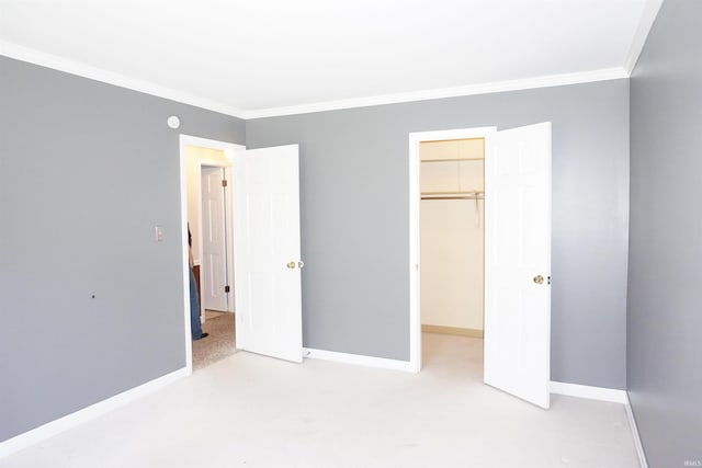 unfurnished bedroom with baseboards, ornamental molding, and a walk in closet