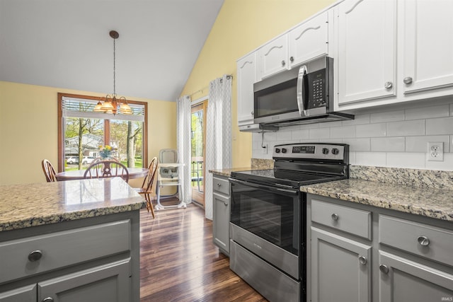 kitchen featuring gray cabinetry, appliances with stainless steel finishes, decorative backsplash, and vaulted ceiling