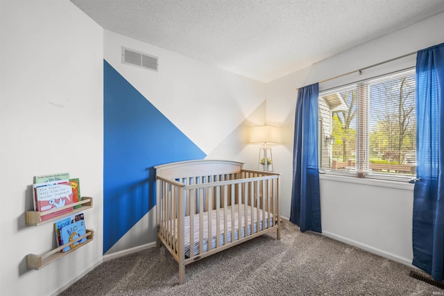 bedroom with visible vents, a textured ceiling, and carpet