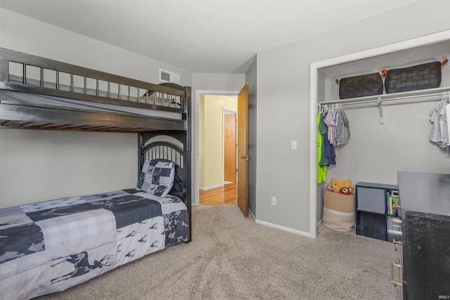 bedroom featuring visible vents, baseboards, carpet floors, and a closet