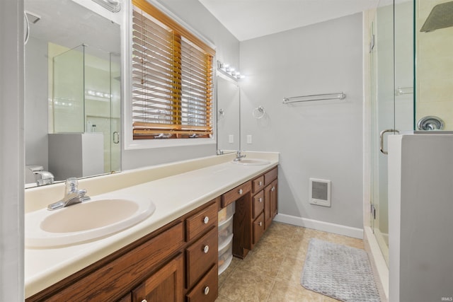 bathroom featuring double vanity, tile patterned floors, a sink, and a stall shower