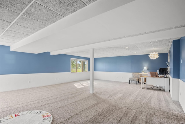 below grade area featuring carpet floors and a wainscoted wall
