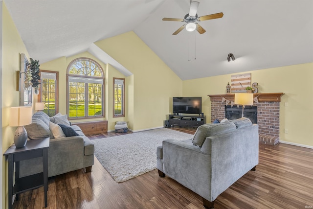 living area with a brick fireplace, wood finished floors, vaulted ceiling, and ceiling fan