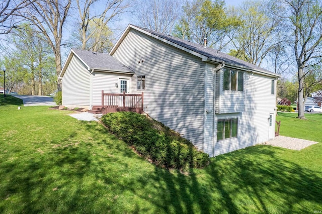 view of home's exterior with a wooden deck and a yard