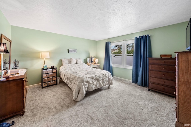 carpeted bedroom featuring a textured ceiling and baseboards