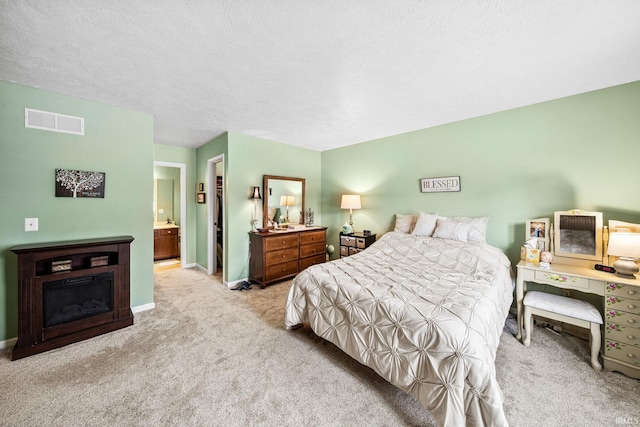 bedroom featuring visible vents, a textured ceiling, carpet floors, and baseboards