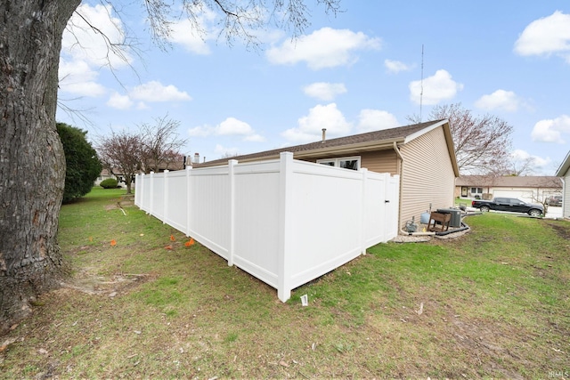 view of side of home featuring a yard and fence