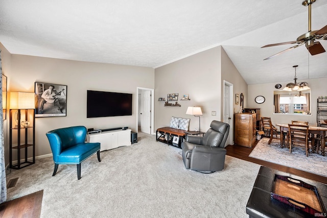 living room featuring carpet flooring, baseboards, and ceiling fan with notable chandelier