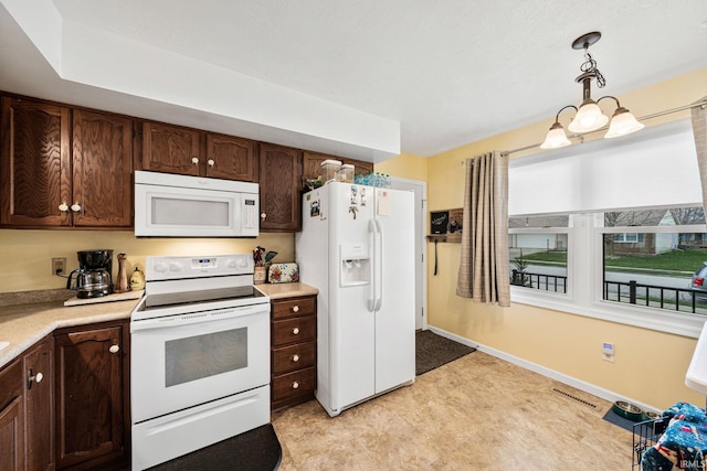 kitchen with light countertops, white appliances, and dark brown cabinets