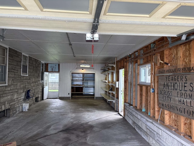 garage with wooden walls and a garage door opener