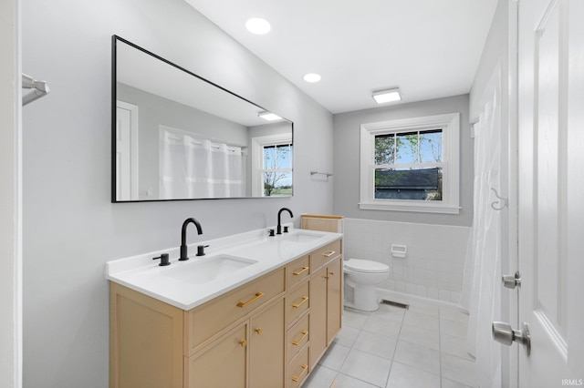 9231 Minnich Rd, Fort Wayne, IN 46816 - bathroom featuring a sink, tile patterned floors, double vanity, and tile walls