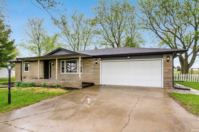 9231 Minnich Rd, Fort Wayne, IN 46816 - ranch-style home with concrete driveway, an attached garage, fence, and a front lawn