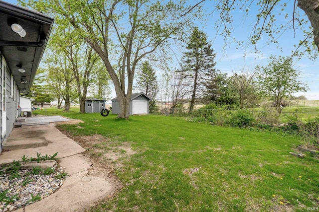 9231 Minnich Rd, Fort Wayne, IN 46816 - view of yard featuring fence, a storage unit, an outbuilding, and a detached garage