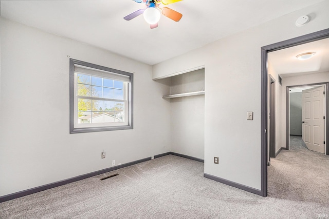 unfurnished bedroom featuring visible vents, baseboards, a closet, and light colored carpet