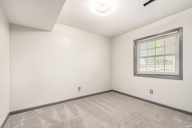 spare room with baseboards and carpet flooring