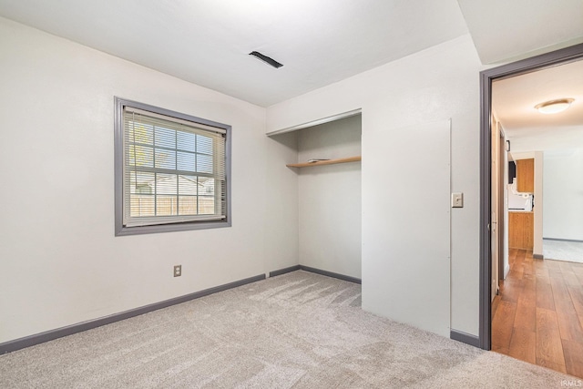 unfurnished bedroom with baseboards, carpet, and a closet