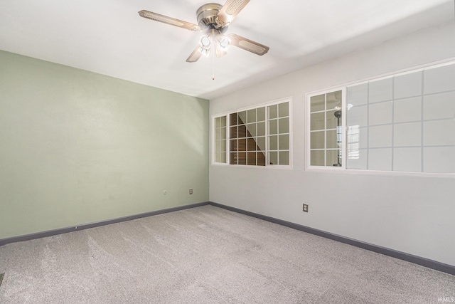 unfurnished room with carpet floors, baseboards, and a ceiling fan