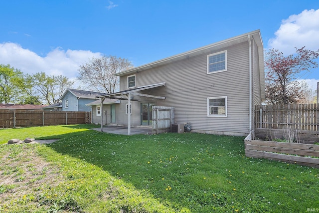 back of property with a patio, a fenced backyard, a garden, and a yard