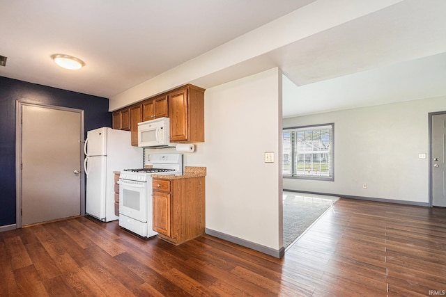 kitchen featuring brown cabinets, baseboards, white appliances, and dark wood-type flooring