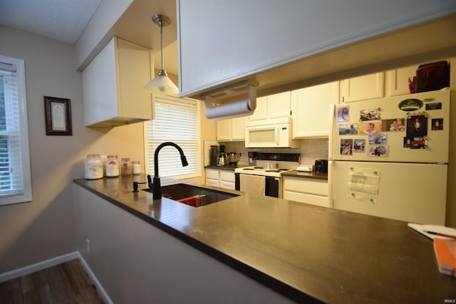 10035 N Turkey Creek Rd, Syracuse, IN 46567 - kitchen with dark countertops, a sink, white appliances, baseboards, and dark wood-style floors