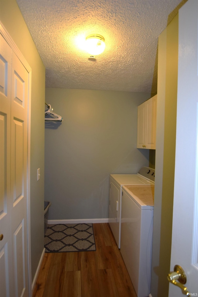 10035 N Turkey Creek Rd, Syracuse, IN 46567 - laundry room featuring a textured ceiling, cabinet space, independent washer and dryer, and wood finished floors