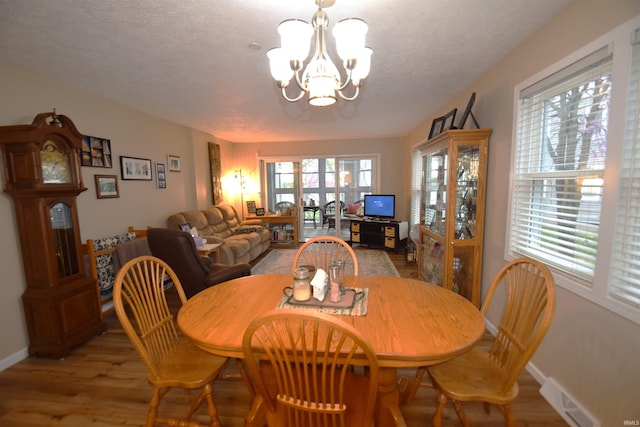10035 N Turkey Creek Rd, Syracuse, IN 46567 - dining area featuring plenty of natural light, light wood-style flooring, a notable chandelier, and visible vents
