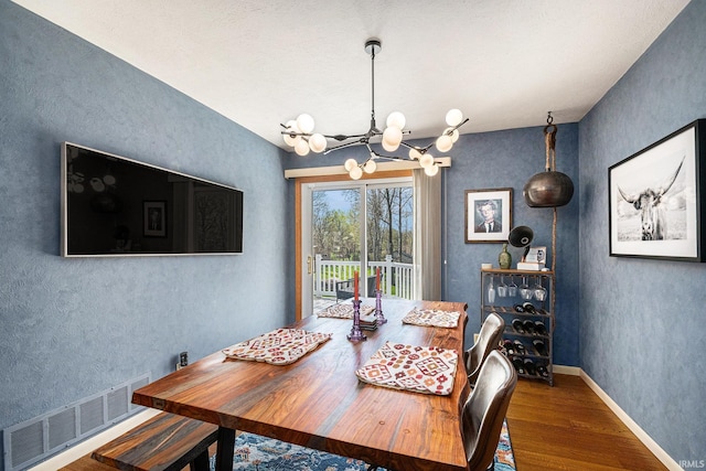 29130 County Road 22, Elkhart, IN 46517 - dining area featuring a textured wall, a notable chandelier, baseboards, wood finished floors, and visible vents