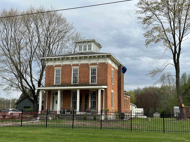 13546 Brick Rd, Granger, IN 46530 - italianate home with a porch, brick siding, a fenced front yard, and a front yard