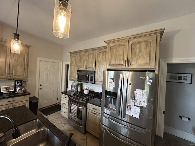 13546 Brick Rd, Granger, IN 46530 - kitchen featuring dark countertops, appliances with stainless steel finishes, a sink, decorative light fixtures, and light tile patterned floors