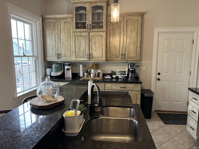 13546 Brick Rd, Granger, IN 46530 - kitchen with light tile patterned floors, a healthy amount of sunlight, a sink, and glass insert cabinets