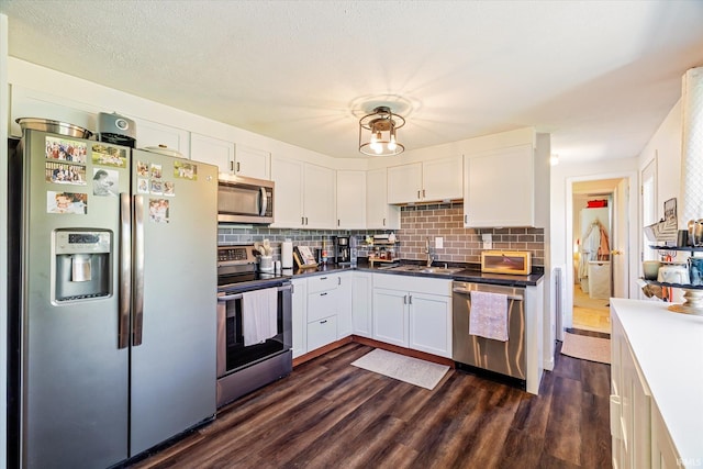 kitchen featuring a sink, appliances with stainless steel finishes, white cabinets, and backsplash