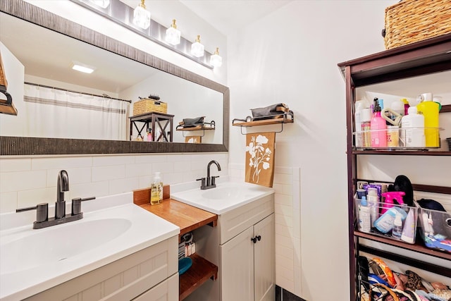 bathroom with double vanity, decorative backsplash, and a sink