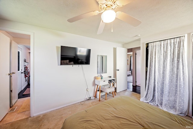 bedroom with light colored carpet, a textured ceiling, a ceiling fan, baseboards, and visible vents