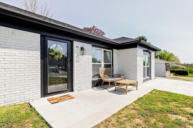 property entrance with brick siding and a patio area